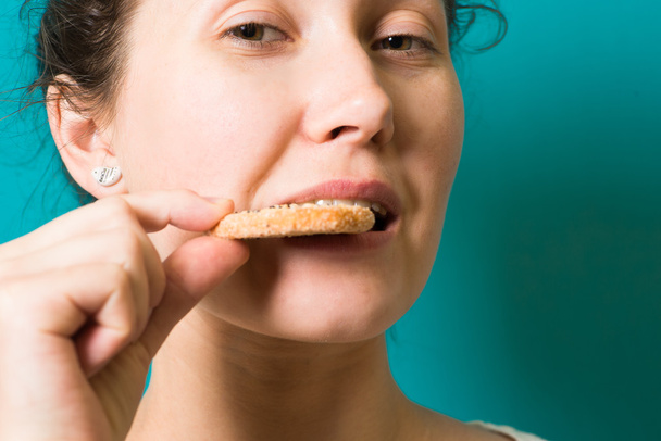 mooie brunette meisje eten cookie - Foto, afbeelding
