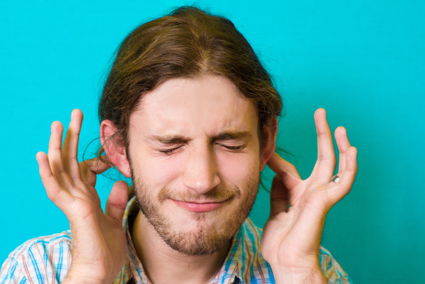 giovane uomo abilmente copre le orecchie
 - Foto, immagini