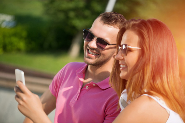 smiling couple using smartphone - Photo, image