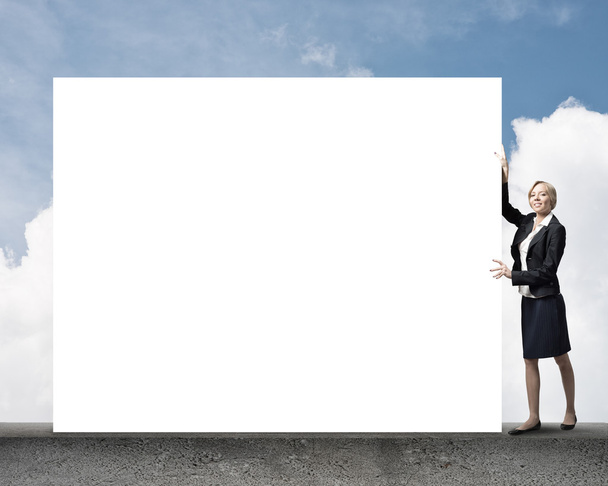 Young businesswoman holding white blank - Valokuva, kuva