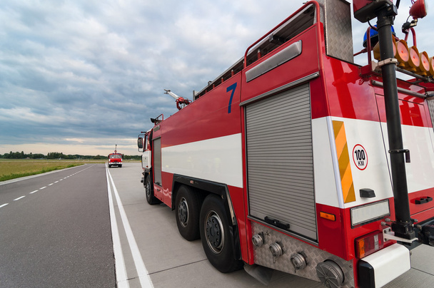 Feuerwehrauto oder Löschfahrzeug unterwegs. Rückseite, weites Objektiv. blauer Himmel Hintergrund - Foto, Bild