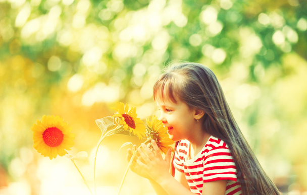 Little girl with sunflowers  - Фото, изображение