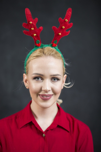 Pretty blond woman in a red reindeer Hat with a merry smile look - Valokuva, kuva