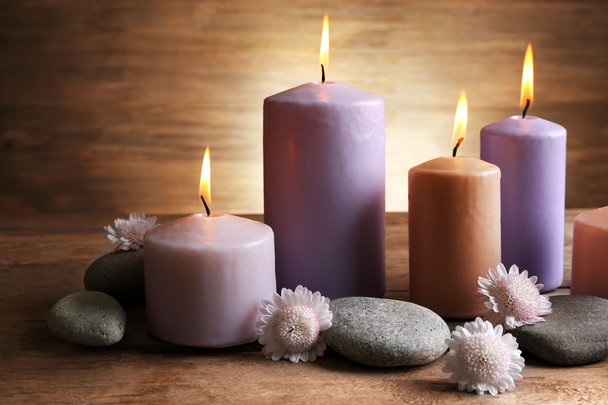 Spa set with candles, pebbles and flowers on wooden background, close up - Фото, зображення