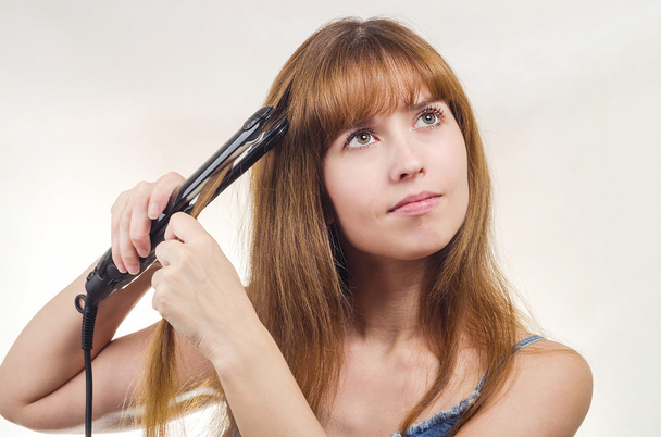 La mujer corrige las pinzas para el cabello
 - Foto, Imagen