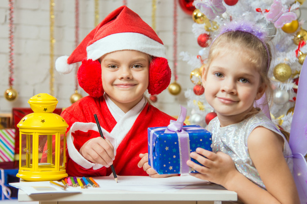 Père Noël et aide fée préparé des cartes de voeux et des cadeaux
 - Photo, image