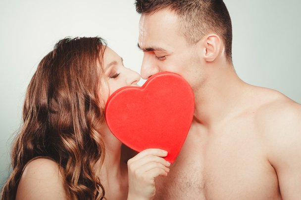 Loving couple kissing behind red heart. Love. - Zdjęcie, obraz