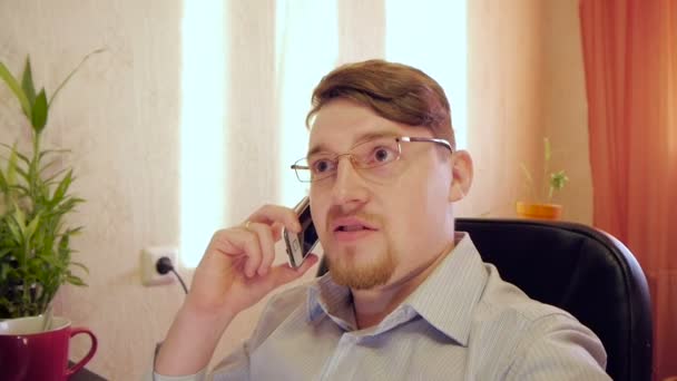 podnikatel v brýlích mluvící telefon v kanceláři - Záběry, video