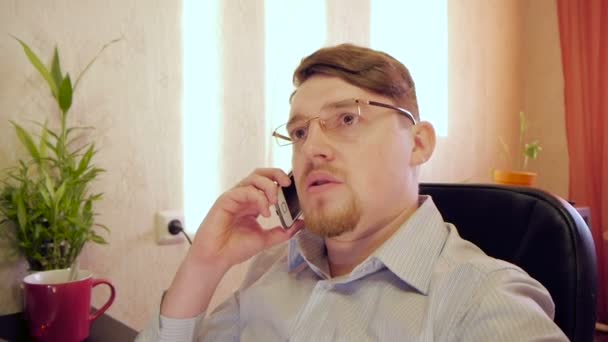 uomo d'affari in occhiali telefono parlante in ufficio
 - Filmati, video