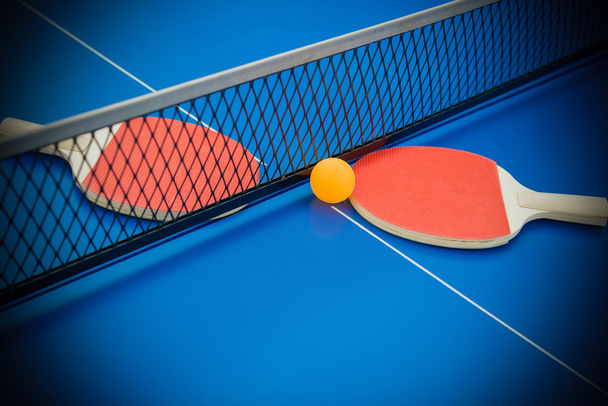 Pingpong mailat ja pallo korostettu sininen pingpong pöytä
 - Valokuva, kuva