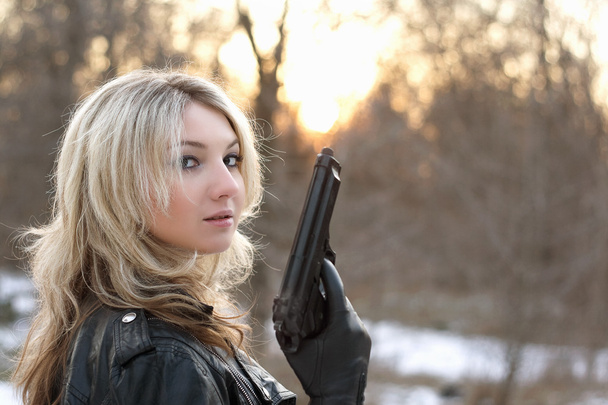 provocerende jonge vrouw met een pistool - Foto, afbeelding