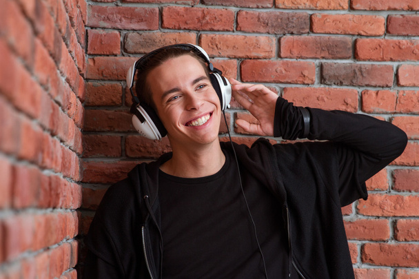 Smiling casual man listening music in headphones - 写真・画像