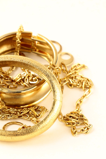 Золотые украшения, браслеты и цепи на белом фоне
 - Фото, изображение