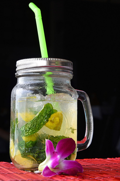 Big glass of mojito with orchid flower on black - Photo, Image