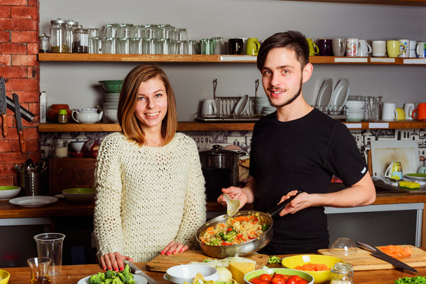 若いカップルがキッチンで調理 - 写真・画像