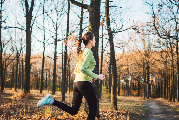 mujer corriendo en el parque. Mujer joven corriendo en el bosque de otoño
 - Foto, imagen