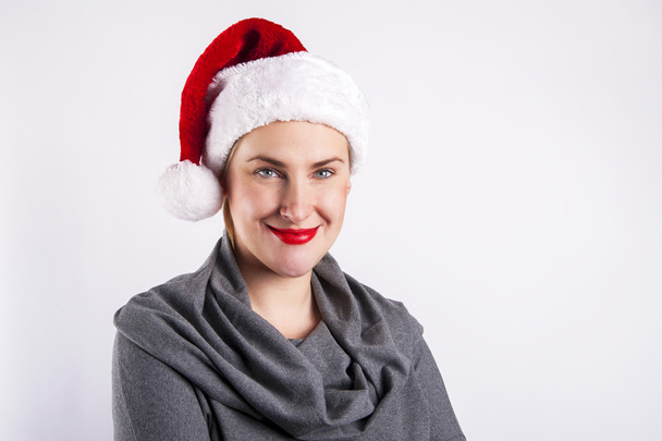 Mujer en sombrero de Navidad sonriendo sobre fondo blanco
. - Foto, imagen