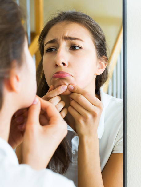 Girl popping a pimple - 写真・画像