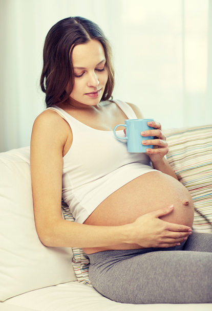 mujer embarazada feliz con taza de té en casa
 - Foto, Imagen
