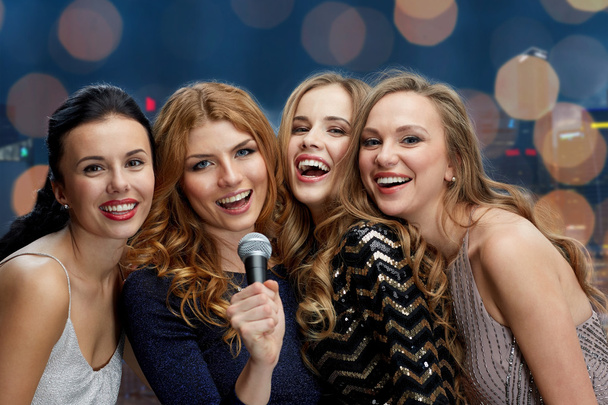 happy young women with microphone singing karaoke - Фото, зображення