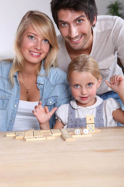 Parents and daughter playing dominoes - Foto, imagen
