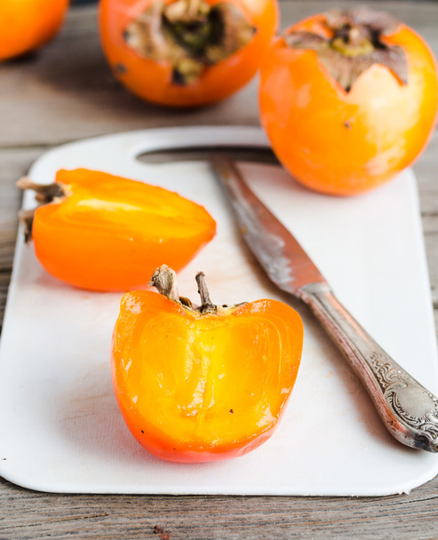 Fresh juicy persimmons on a light background, raw fruit - Foto, immagini