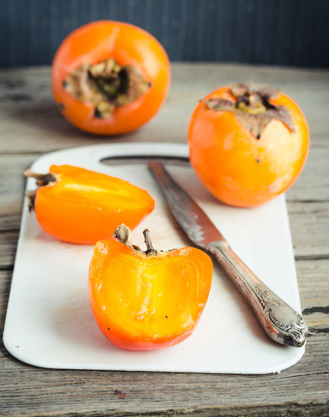 Fresh juicy persimmons on a light background, raw fruit - 写真・画像