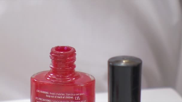 Βάζοντας βούρτσα στο μπουκάλι κόκκινο βερνίκι νυχιών - Πλάνα, βίντεο