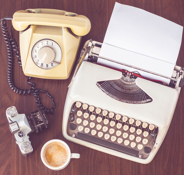 una vieja máquina de escribir sobre una vieja mesa de madera con café y una vieja cámara
 - Foto, Imagen