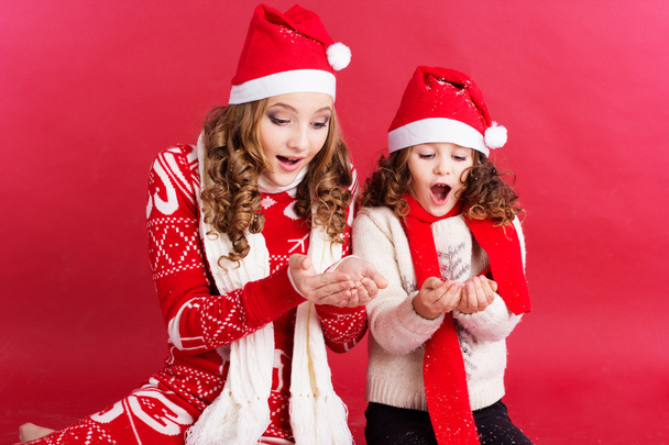 Two girls are blowing fake snow - 写真・画像