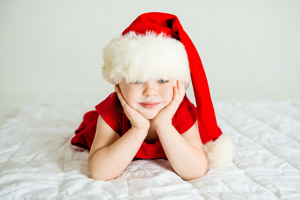 Little Girl smiling in Hat Santa - 写真・画像