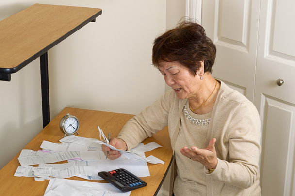 Ηλικιωμένη γυναίκα που είναι απογοητευμένοι από την οικονομική τους λογαριασμούς - Φωτογραφία, εικόνα