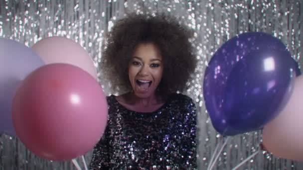 Afro american excited woman holding bunch of colorful balloons in studio. - Metraje, vídeo