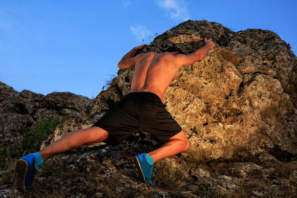 Young man climbing the mountain ridge - Valokuva, kuva