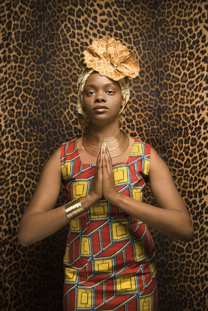 Young African American Woman Praying and Wearing Traditional African Dress - Photo, image
