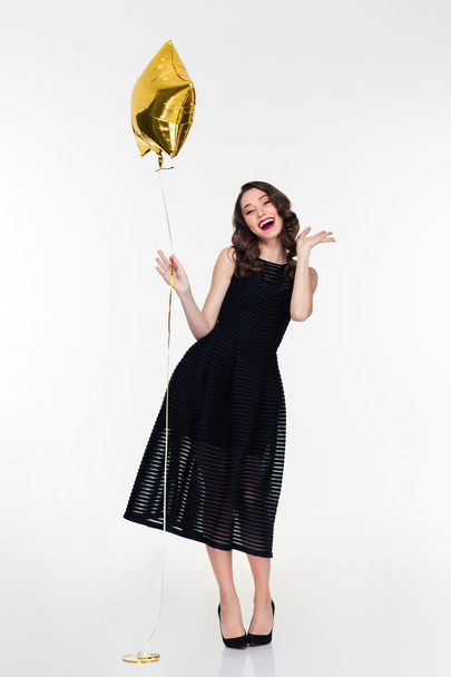 Cheerful woman with makeup in retro style holding golden balloon  - Fotografie, Obrázek