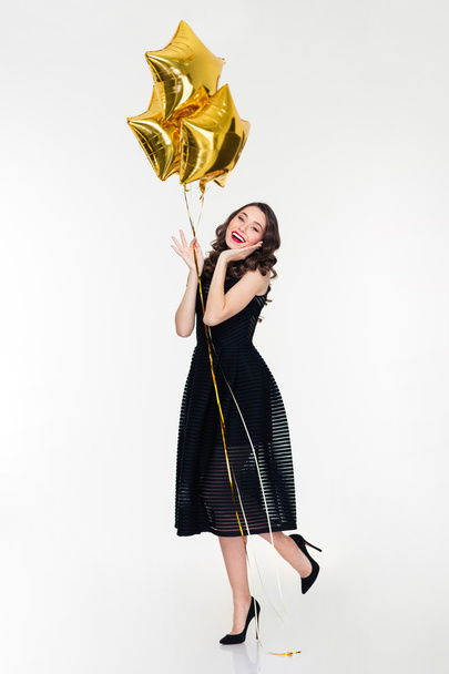 Charming smiling young curly female holding balloons - Fotoğraf, Görsel