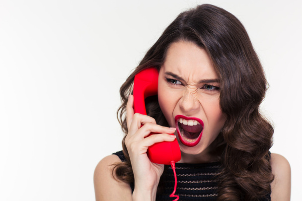 Angry woman in retro style screaming and talking on telephone - Foto, immagini