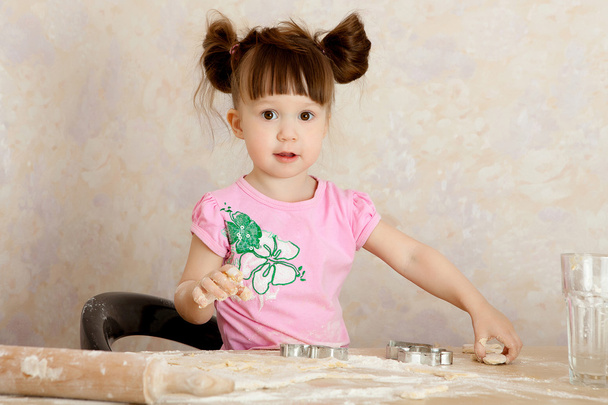 Young girl kneading dough - Foto, afbeelding