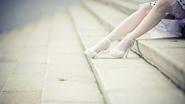 Legs of a bride sitting on step - Фото, изображение