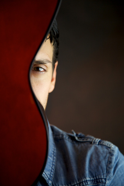 Male model behind guitar portrait - Photo, Image