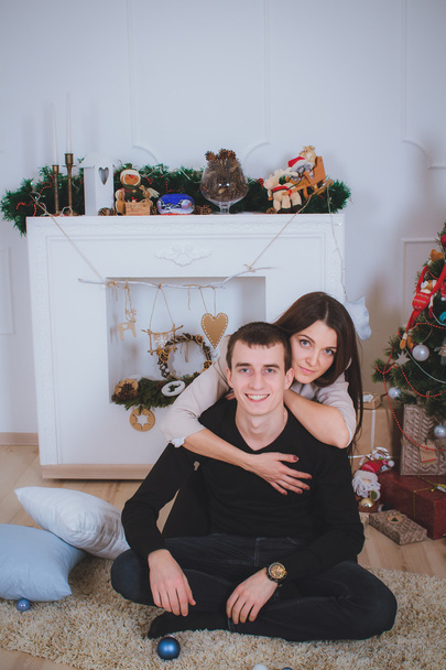 man and woman hugging, lie near the Christmas tree - Фото, изображение