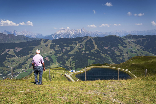 Old man looking at idyllic summer landscape with Alps mountains, Austria - 写真・画像