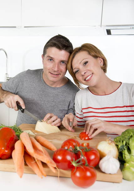 joven pareja americana trabajando en casa cocina preparación vegetal ensalada juntos sonriendo feliz
 - Foto, Imagen