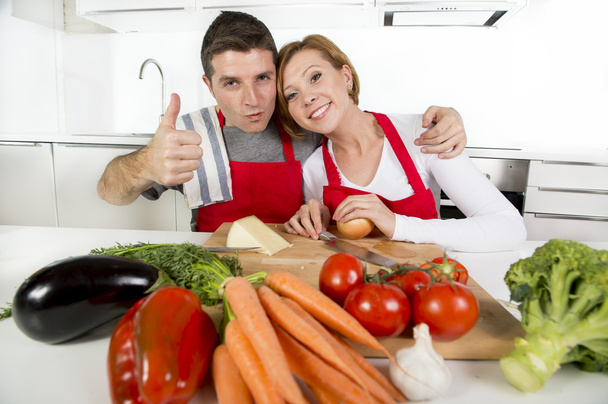 молодая красивая пара, работающая на домашней кухне, готовящая овощной салат вместе улыбаясь счастливой
 - Фото, изображение