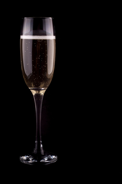 A glass of champagne on black background - Фото, зображення