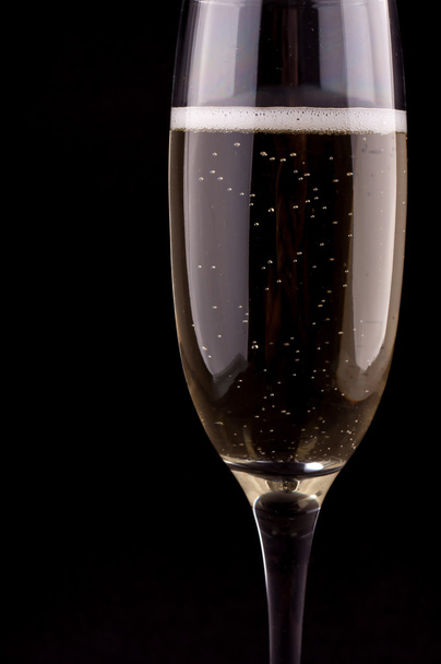 A glass of champagne on black background - Фото, изображение