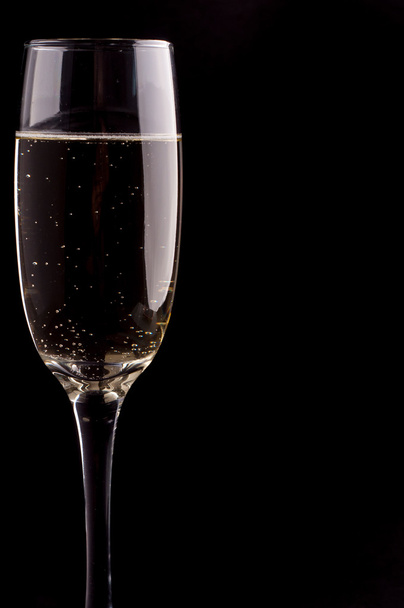 A glass of champagne on black background - Foto, immagini