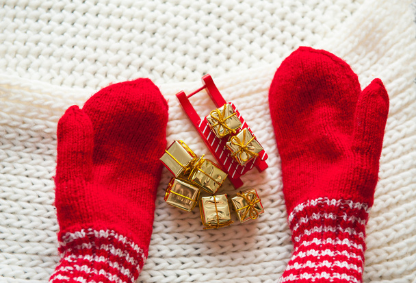 red knitted mittens sled and golden gifts. The concept of Christmas - Foto, immagini