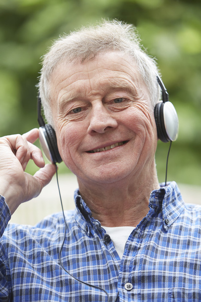 Senior Man Relaxing Listening To Music On Headphones - 写真・画像